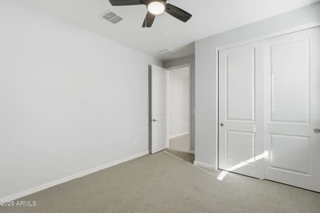 an empty room with chandelier fan