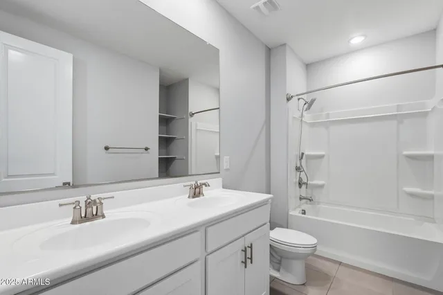 a bathroom with a double vanity sink toilet mirror and bathtub