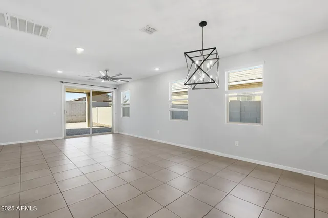 a view of empty room with windows and ceiling fan
