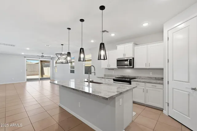a kitchen with stainless steel appliances granite countertop a sink a stove and cabinets