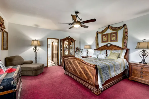 a bedroom with a large bed and windows