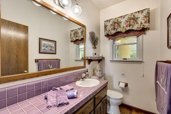 a bedroom with a bed a mirror and windows