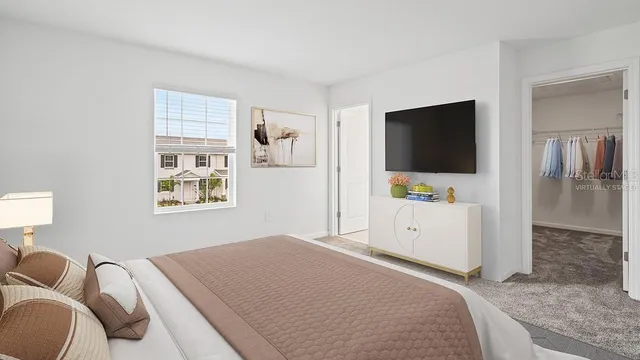 a bedroom with a bed and a flat screen tv