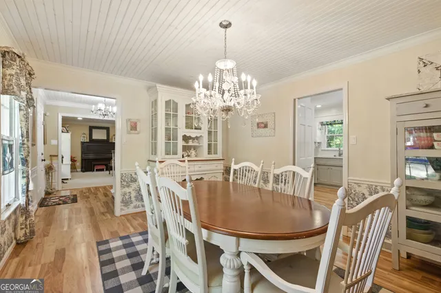 a dining room with furniture a chandelier and wooden floor