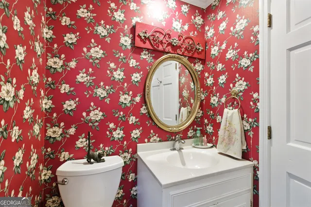 a bathroom with a toilet sink and mirror