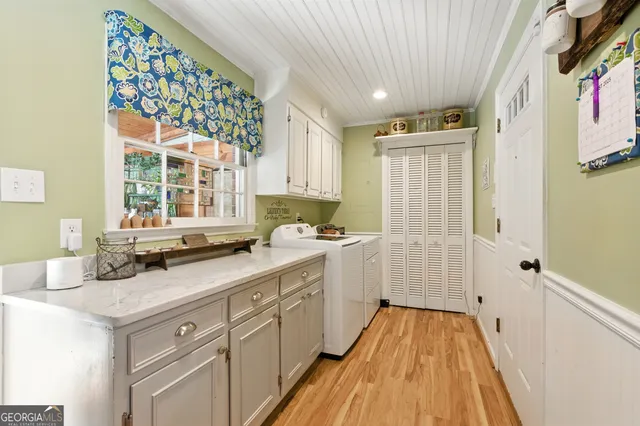 a view of a kitchen with a sink wooden cabinets and entryway