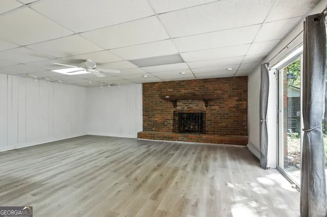 an empty room with wooden floor and fireplace