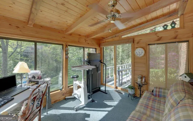 a living room with furniture tv and a floor to ceiling window