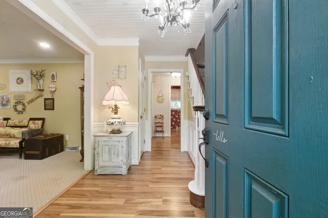 a hallway with a chandelier and wooden floor