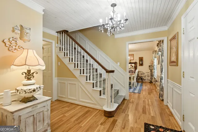 a view of a room with wooden floor and chandelier