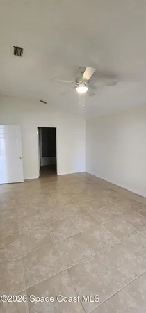 a view of empty room with a ceiling fan and window