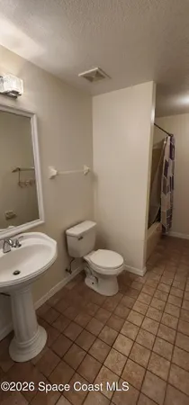 a white toilet sitting next to a bathroom sink and vanity