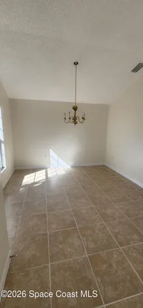 an empty room with a ceiling fan and carpet
