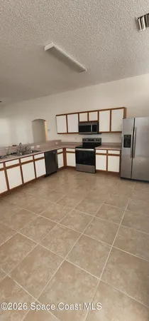 a view of a livingroom with furniture and empty kitchen