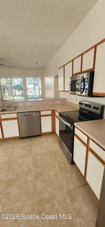 a kitchen with stainless steel appliances granite countertop a sink and wooden cabinets