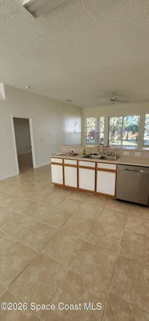 a large white kitchen with granite countertop a sink and a stove
