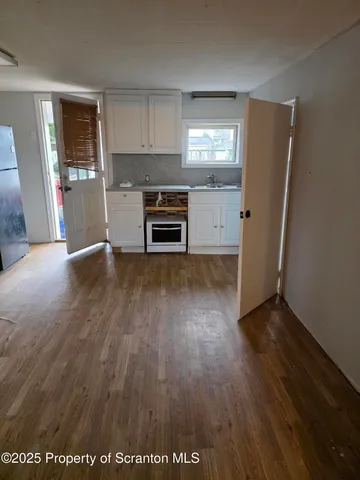 an empty room with wooden floor and fireplace
