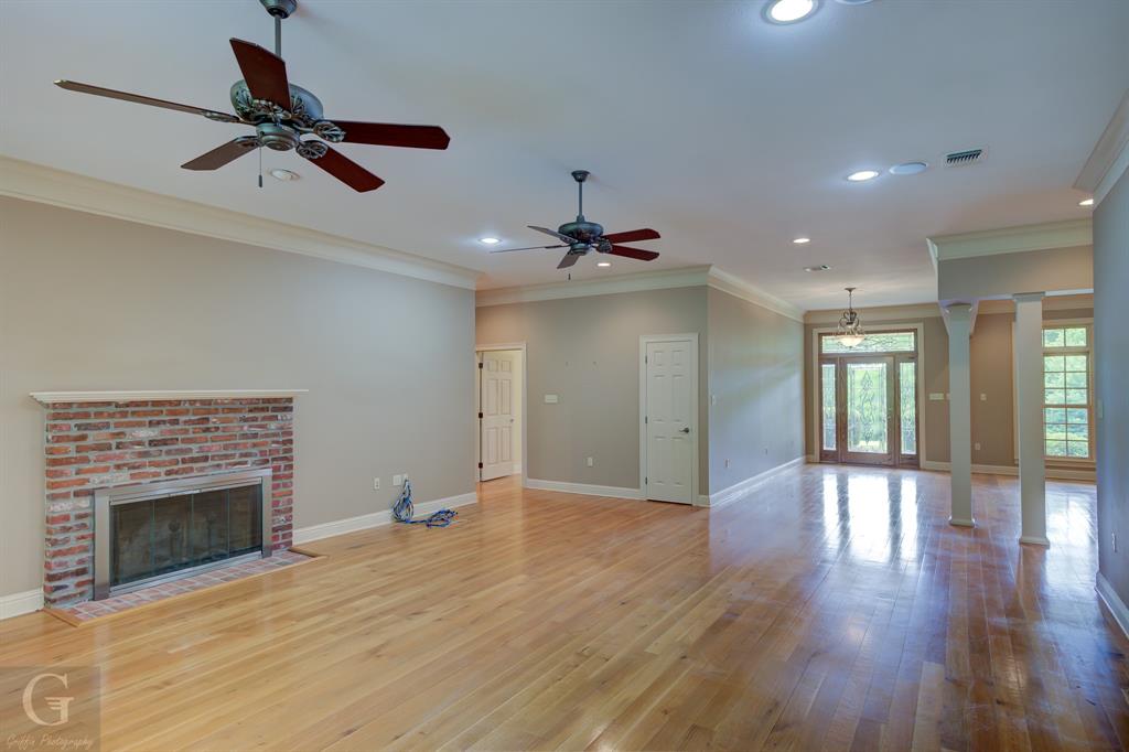 1212 WPA Road Homer, LA 71040 - Photo 11 of 35 Unfurnished living room with ceiling fan, a fireplace, recessed lighting, wood finished floors, and ornamental molding