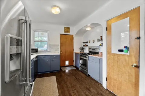 a kitchen with a refrigerator and a stove top oven