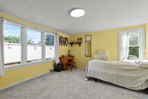 a bedroom with a bed and a large window