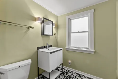 a bathroom with a sink toilet and window