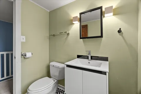 a bathroom with a toilet a sink and mirror