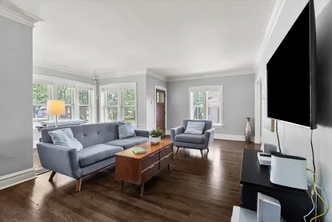 a living room with furniture flat screen tv and wooden floor