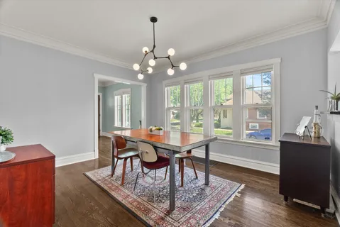 a dining room with furniture a chandelier and wooden floor