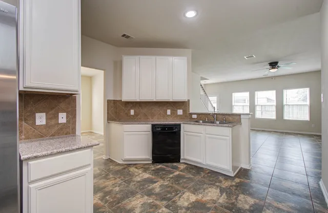a kitchen with granite countertop white cabinets and white appliances