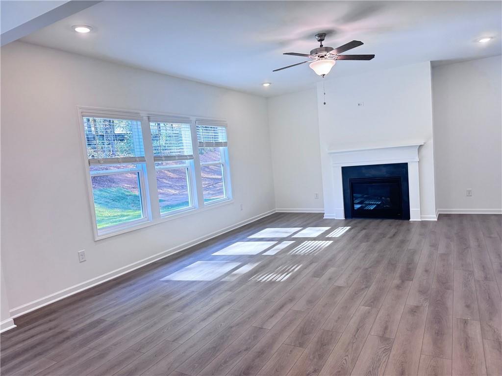 334 Silverleaf Trail Bethlehem, GA 30620 - Photo 12 of 30 wooden floor fireplace and windows in an empty room