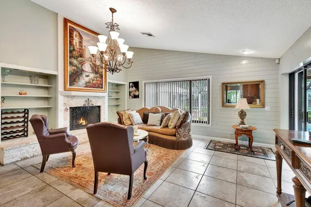 a living room with furniture a fireplace and a chandelier