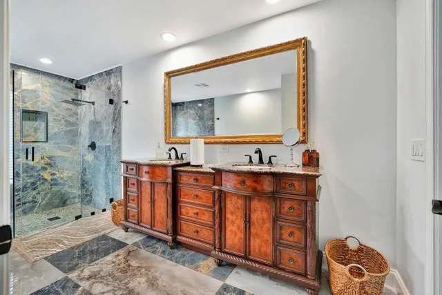 a bathroom with a double vanity sink mirror and shower