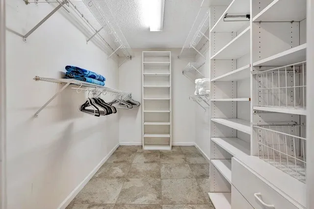 a view of walk in closet with empty racks