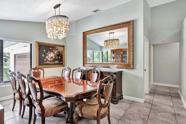 a view of a dining room with furniture a chandelier and window