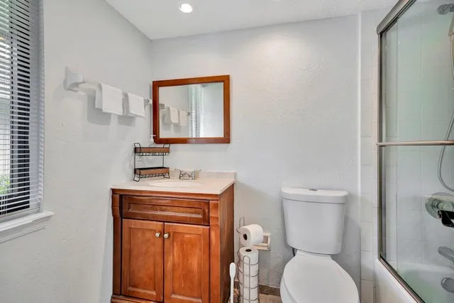 a bathroom with a toilet a sink and mirror