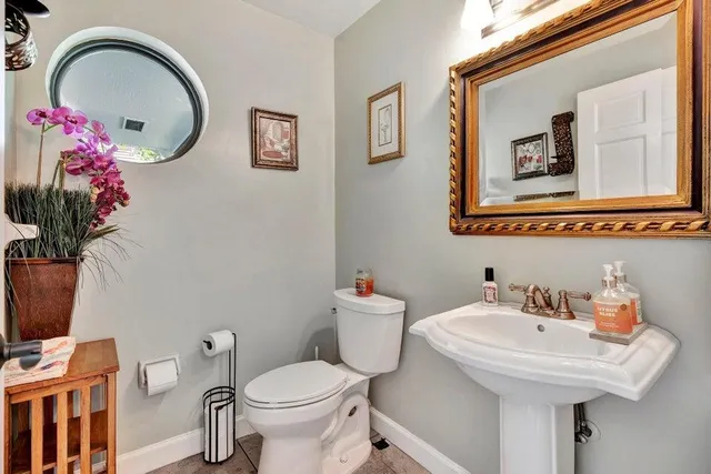a bathroom with a toilet sink and mirror