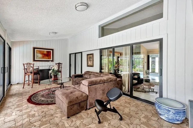 a living room with furniture fireplace and large windows