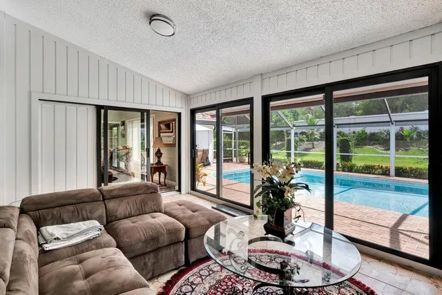 a living room with furniture and a floor to ceiling window