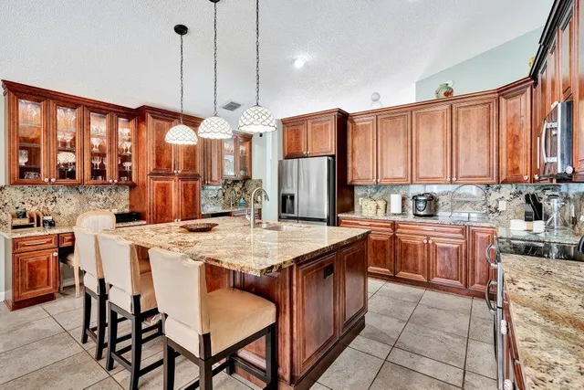 a kitchen with stainless steel appliances granite countertop wooden cabinets a center island and stainless steel appliances