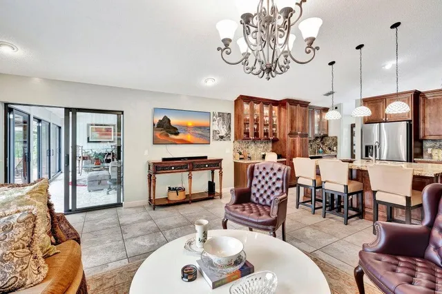a living room with furniture kitchen view and a wooden floor