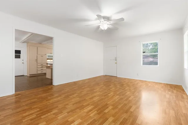 a view of empty room with wooden floor