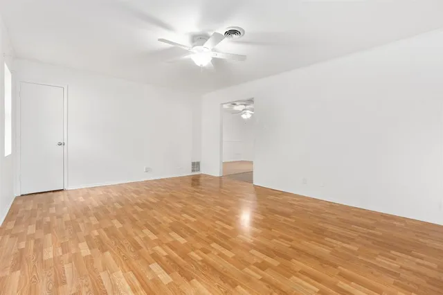 a view of empty room with wooden floor