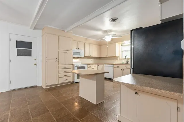 a kitchen with a sink cabinets and stainless steel appliances