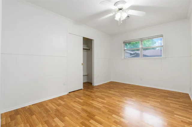 an empty room with a window and a ceiling fan