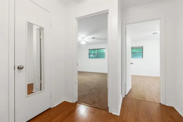 an entryway with wooden floor and a bathroom