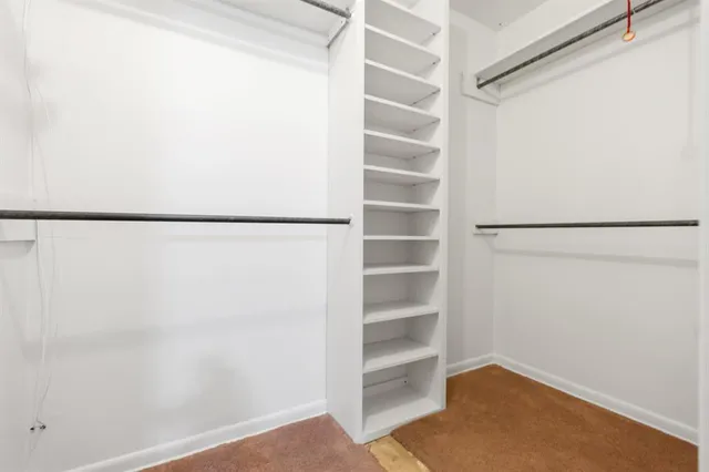 a view of walk in closet with empty racks