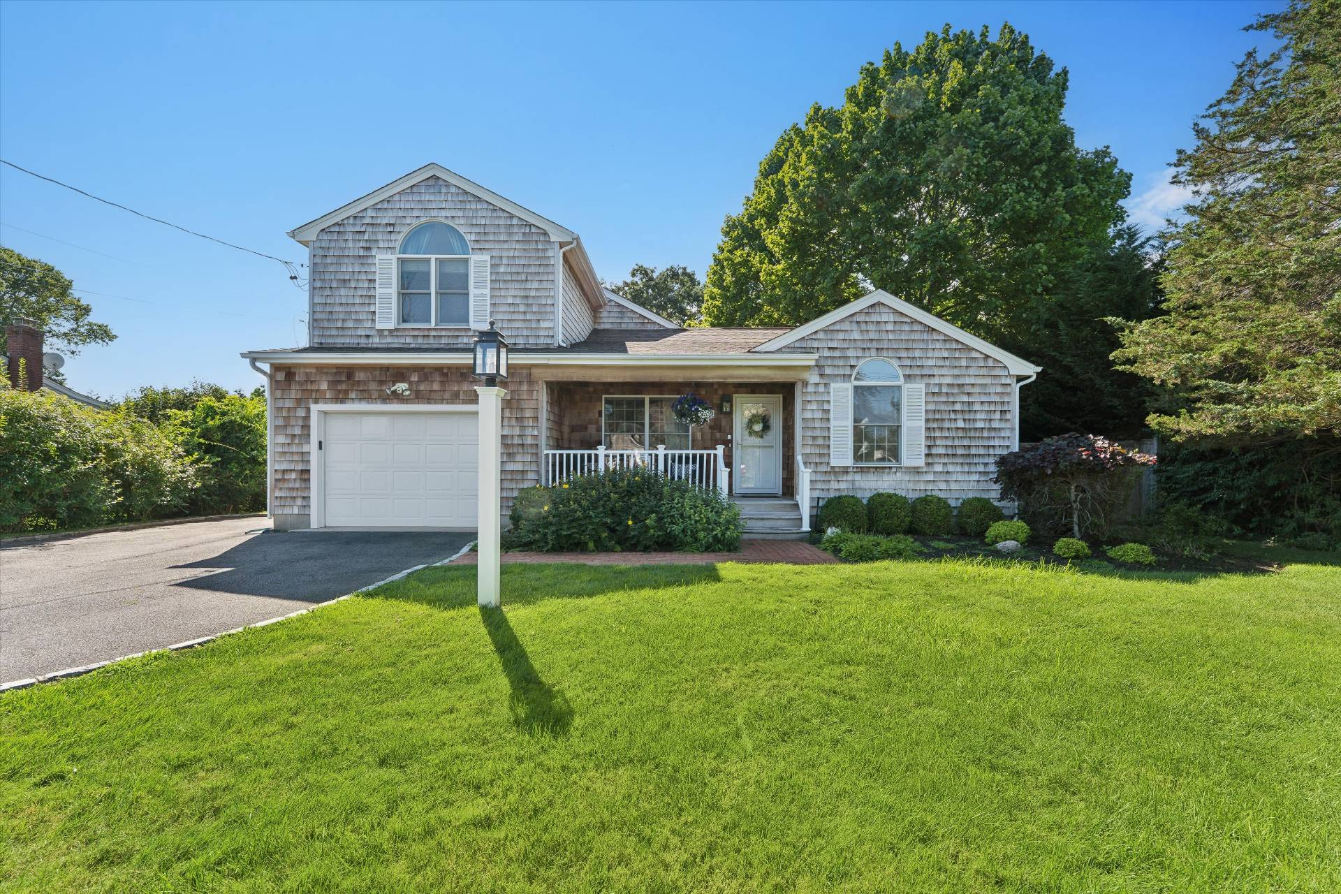 19 Maple Street Westhampton Beach, NY 11978 - Photo 2 of 23 a front view of a house with a yard and garage