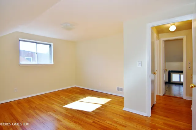 a view of empty room with wooden floor