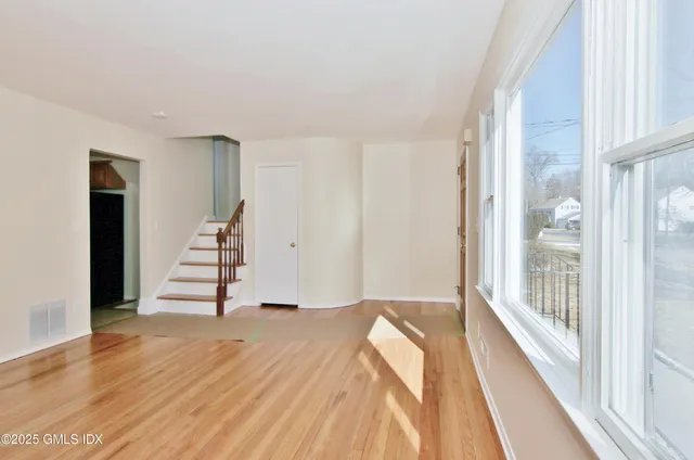 a view of empty room with wooden floor and floor