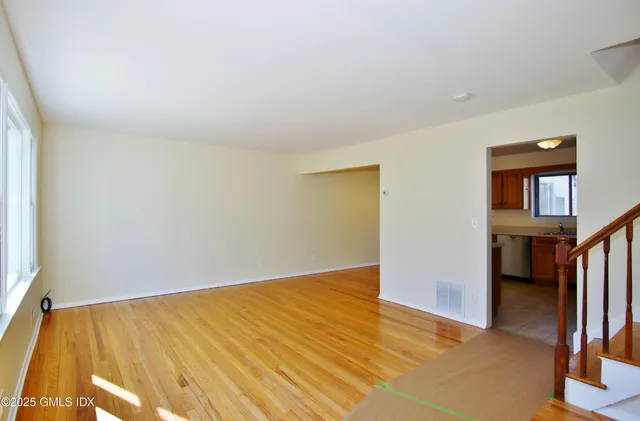 an empty room with wooden floor and a window